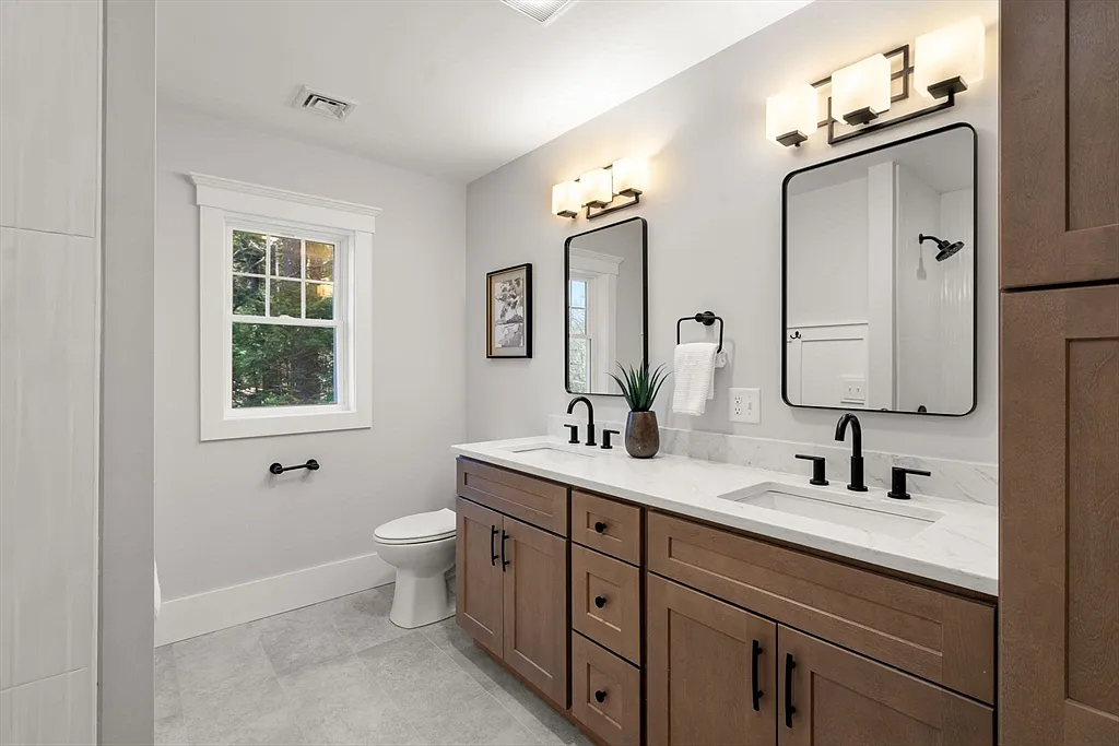 Remodeled bathroom with double vanity and black fixtures